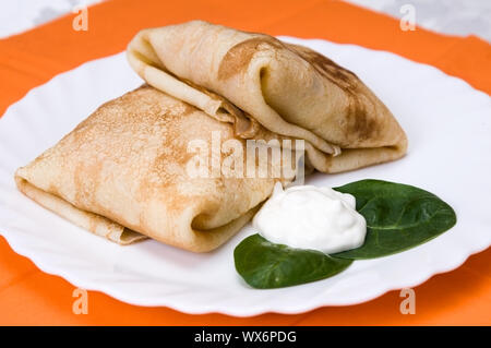 Pila di pancake con imbottitura su una piastra bianca Foto Stock