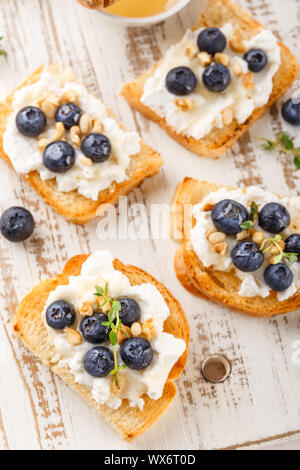 Toast con frutti di bosco freschi mirtillo di ricotta, timo, miele e nocciole, servita Foto Stock