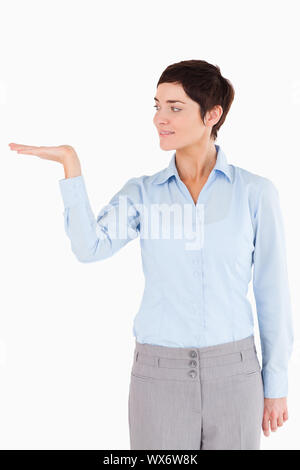 Imprenditrice con una mano aperta per mostrare una copia spazio contro uno sfondo bianco Foto Stock