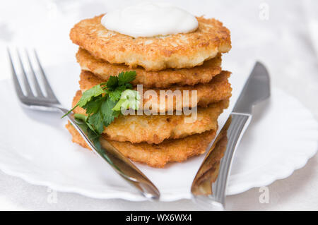 Fritti frittelle di patate al prezzemolo sulla piastra bianca Foto Stock