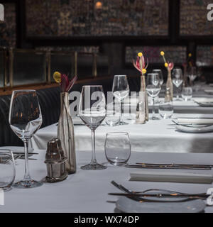 Interno di un moderno ristorante con tavoli serviti a cena Foto Stock