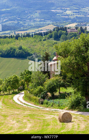 Scenario in Marche Italia con balle di paglia su un campo Foto Stock