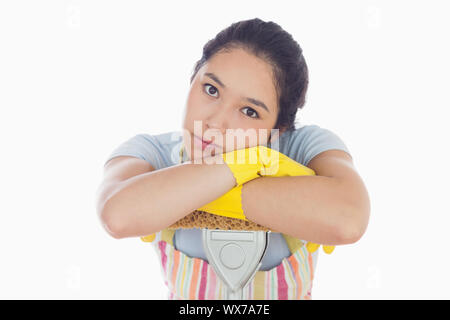 Triste donna appoggiata sopra la radazza che indossa il suo grembiule Foto Stock