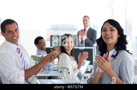 Businessteam applaudire un collega dopo una presentazione in ufficio Foto Stock