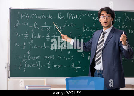 Giovane maschio insegnante di matematica in aula Foto Stock