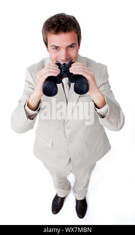 Imprenditore sorridente usando un paio di binocoli contro uno sfondo bianco Foto Stock