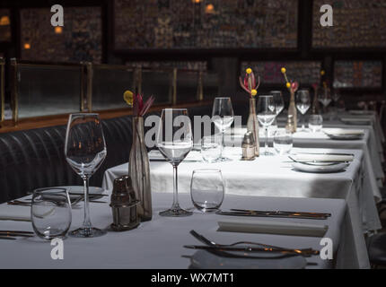 Interno di un moderno ristorante con tavoli serviti a cena Foto Stock