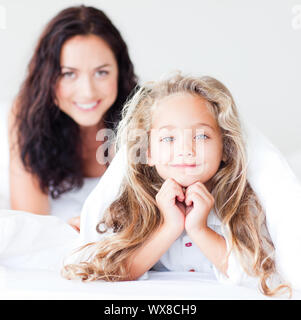 Affascinante madre e figlia abbracciando sul letto Foto Stock