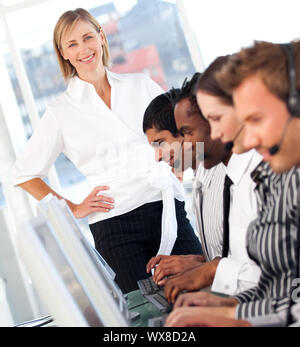 Femmina radiante leader con un team su un call center Foto Stock