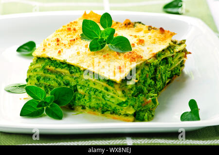 Servire fresca di forno vegetariano lasagne spinaci su una piastra Foto Stock