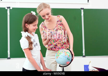 Insegnante spiega la lezione di geografia, stare vicino al mondo della scuola Foto Stock