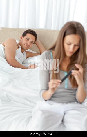 Adorabili uomo che guarda la sua ragazza il deposito il suo dito unghie sul letto di casa Foto Stock