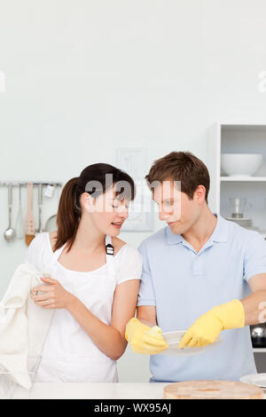 Gli amanti del lavaggio piatti insieme nella loro cucina Foto Stock