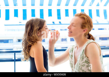 Bambini ragazza madre con applicazione di protezione solare in estate Foto Stock