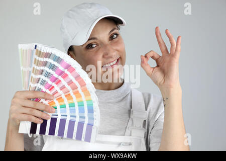 Pittore dando l'un-ok segno e tenendo una tavolozza di campioni di colore Foto Stock