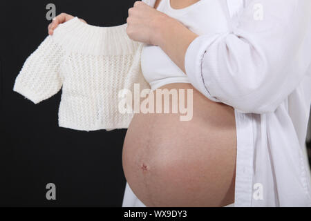 Donna incinta tenendo un bimbo di ponticello Foto Stock