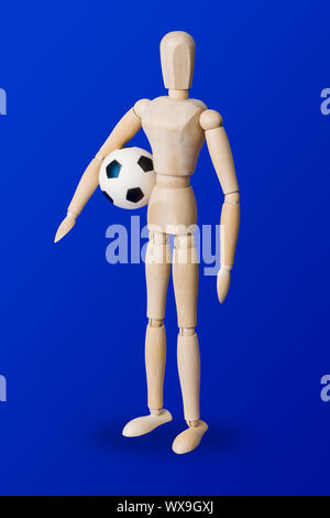 Calcio giocattolo di legno figura su blu Foto Stock