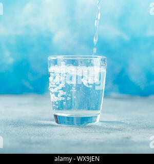 Versando acqua dalla bottiglia in vetro Foto Stock