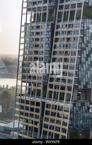 Singapore - Marzo 21, 2019: Closeup dei giardini su vari livelli del grattacielo scuro con lati di vetro. National Stadium di schiena. Foto Stock