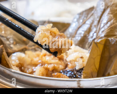 Delizioso Lo Mai Gai dim sum, fresco vapore riso glutinoso con involtini di pollo avvolti da lotus foglie di bambù nel sistema di cottura a vapore in hong kong yumcha ristorante. Foto Stock