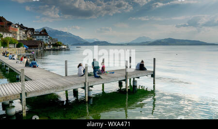 Zugo, ZG / Svizzera - 20 Aprile, 2019: per coloro che godono di una bella giornata di primavera sulla banchina sul lago Foto Stock