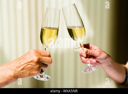 Mano di eldery donna e donna giovane la tostatura con bicchieri di champagne Foto Stock