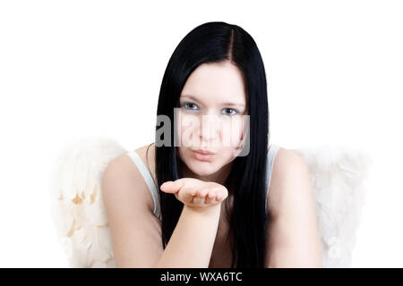 Giovane donna blackhaired con ali d'angelo soffia alcune stelle su sfondo blu Foto Stock