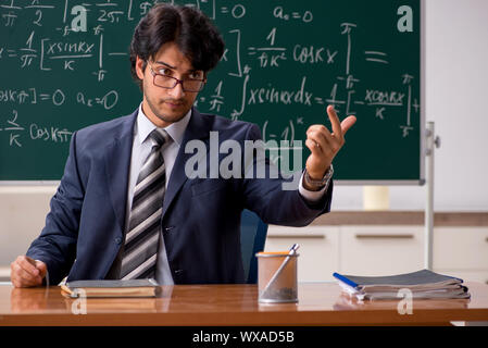 Giovane maschio insegnante di matematica in aula Foto Stock