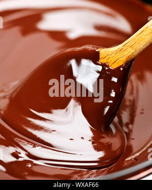 Il cucchiaio di legno morbido di agitazione del fuso di cioccolato ricco Foto Stock