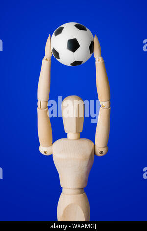 Calcio giocattolo di legno figura su blu Foto Stock