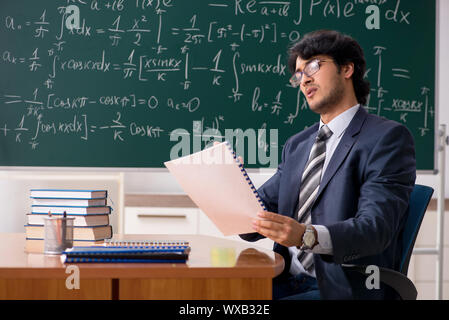 Giovane maschio insegnante di matematica in aula Foto Stock