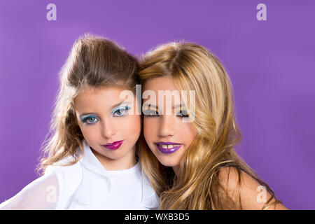 Bambini Due bambini fashiondoll ragazze buoni amici con il trucco di moda su viola Foto Stock