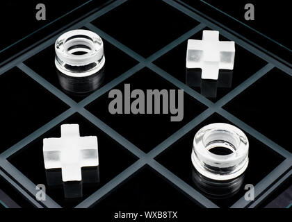 Vetro tic-tac-toe gioco su sfondo nero Foto Stock