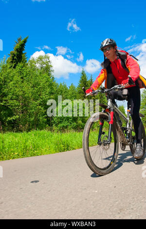 In viaggio per i ciclisti su strada di campagna Foto Stock