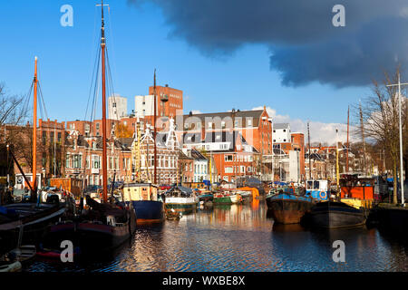 Sunny canal a Groningen con molte imbarcazioni da fiume befire storm Foto Stock