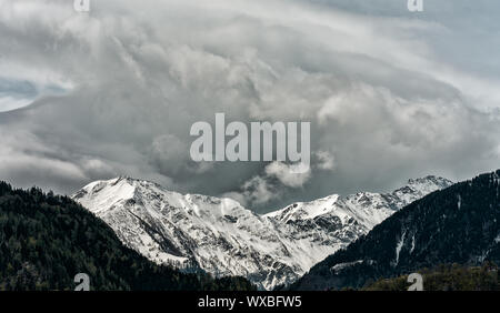 Panorama del paesaggio di montagna con cime innevate e espressiva cloudscape Foto Stock