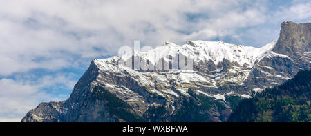 Paesaggio di montagna con cime innevate e espressiva cloudscape Foto Stock