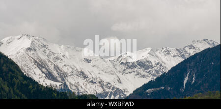 Panorama del paesaggio di montagna con cime innevate e espressiva cloudscape Foto Stock