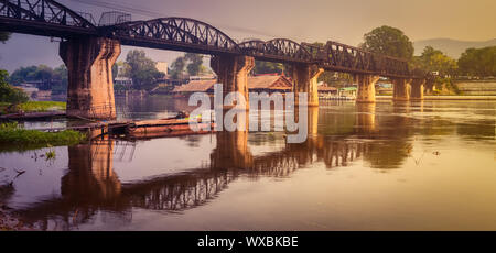 Il ponte sul fiume Kwai a sunrise. Stazione ferroviaria di Kanchanaburi, Thailandia. Panorama Foto Stock