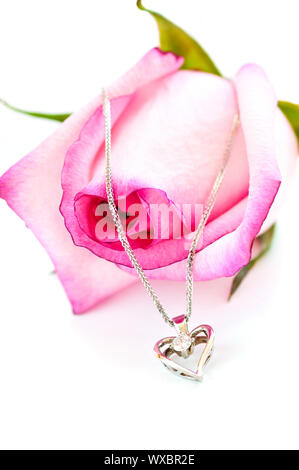 Cuore pendente con diamante con una rosa rosa Foto Stock