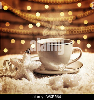 Foto di lusso tazza bianca con gustosi caffè, Christmastime impostazione tabella, tazza di tè su marrone incandescente sfondo, festosa decorazione a stella, Nuovo Anno ornam Foto Stock