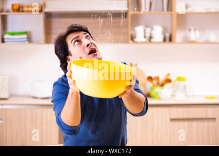 Giovane uomo in perdite di acqua dal concetto di vicini di casa Foto Stock