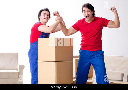 Due giovani contraente i dipendenti che si spostano oggetti personali Foto Stock