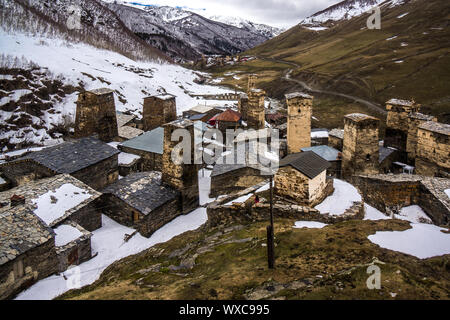 Vista su ushguli le torri di guardia con una verde collina bianco Foto Stock