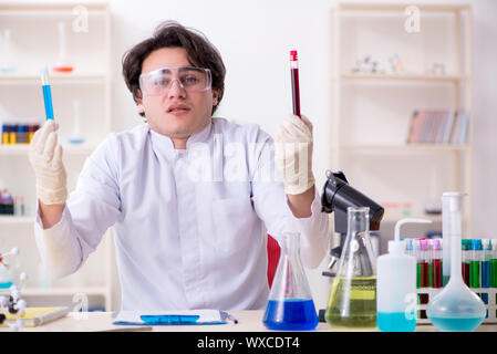 Giovane maschio biochemist il lavoro in laboratorio Foto Stock