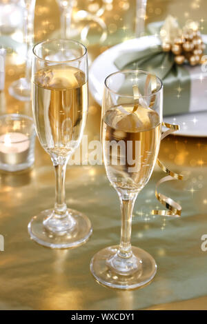 Bicchieri di Champagne sul tavolo per la cena con confezioni regalo Foto Stock