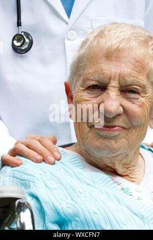 Senior lady in carrozzella con il suo medico Foto Stock