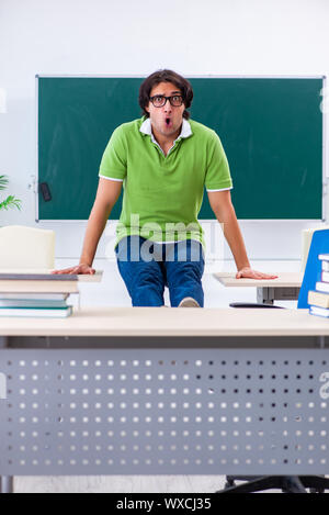 Giovane studente facendo esercizi fisici in aula Foto Stock