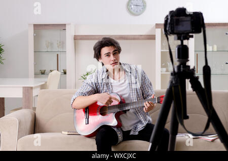 Giovane chitarrista di registrazione di video per il suo blog Foto Stock