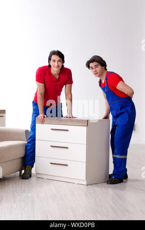 Due giovani contraente i dipendenti che si spostano oggetti personali Foto Stock